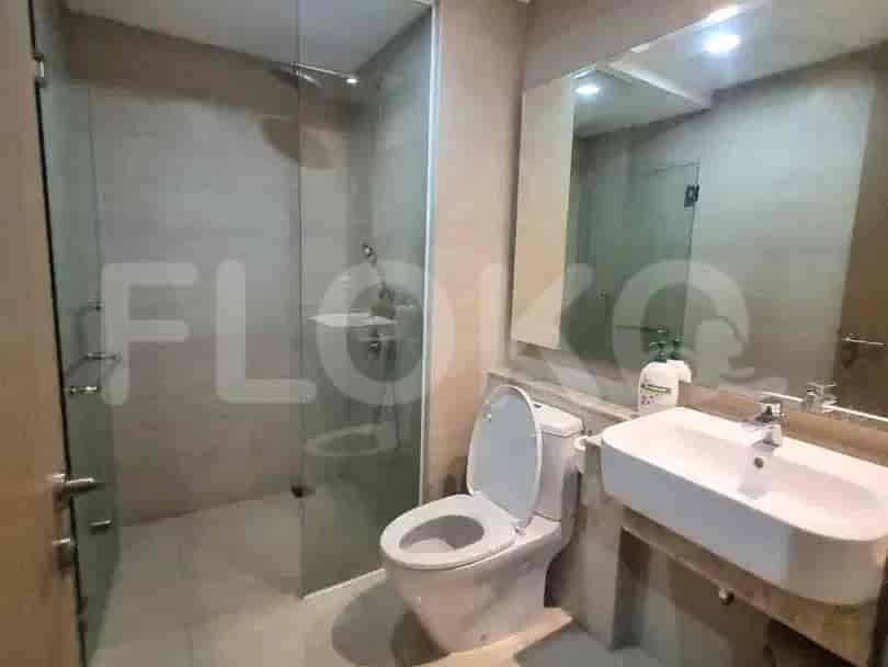 A modern bathroom featuring a walk-in shower, toilet, and a sink with a vanity and mirror.