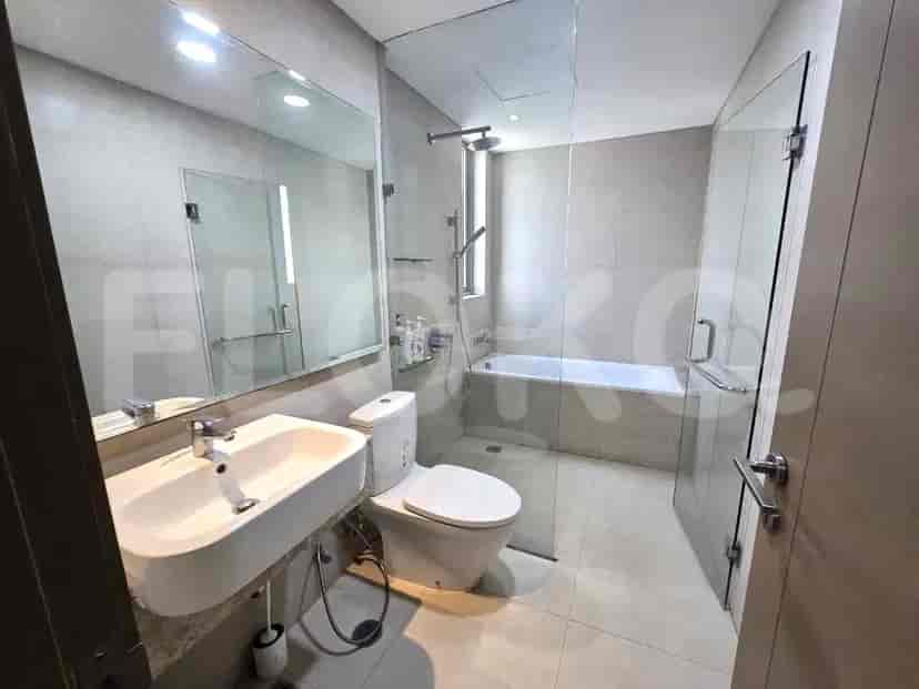 A clean and modern bathroom featuring a sink, toilet, and a glass-enclosed shower and bathtub.