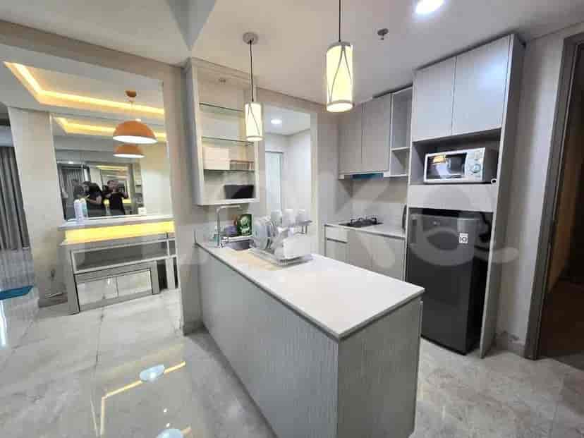 A compact, modern kitchen with light wood cabinets, a countertop, and essential appliances.