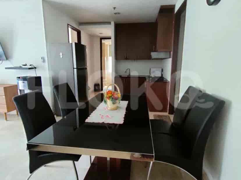A compact kitchen area with dark wood cabinets, a stainless steel refrigerator, and a sink.