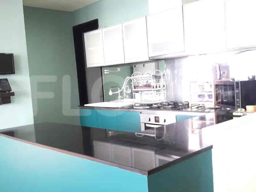 A modern kitchen with stainless steel appliances and light green walls.