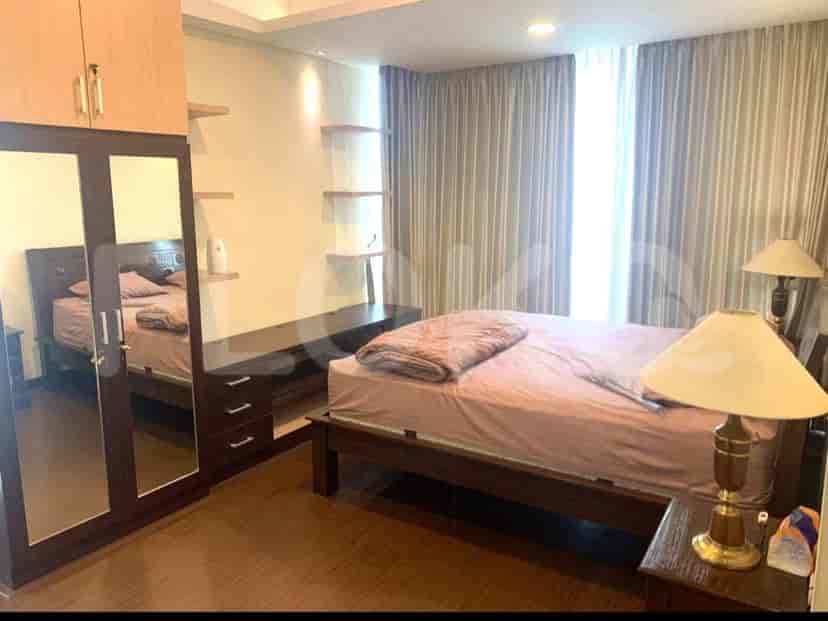 A bedroom with a king-size bed, wardrobe with mirrors, and shelving units.