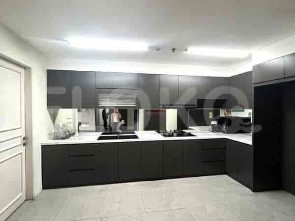 A modern kitchen with dark cabinets, a white countertop, and stainless steel appliances.