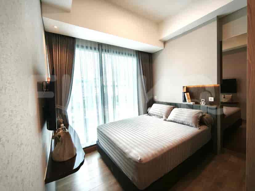 A cozy bedroom with a queen-sized bed, large window with curtains, and a wall-mounted TV.