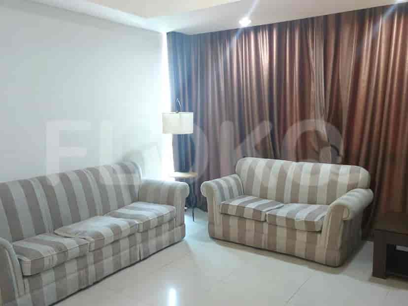 A living room with two striped sofas and a floor lamp.