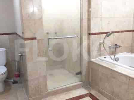 A bathroom with a bathtub, a separate shower cubicle, a toilet, and marble tile walls.
