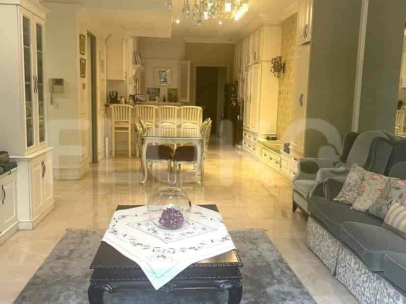 An open-plan living and dining area with a dining table set for four and a plush sofa.
