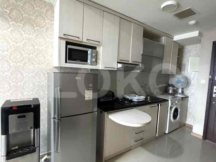 A compact kitchen with appliances including a refrigerator, microwave, stove, and washing machine.