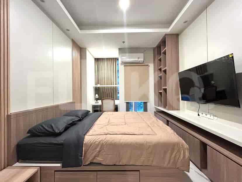 A cozy bedroom with a queen-sized bed, wall-mounted TV, and a built-in wardrobe.