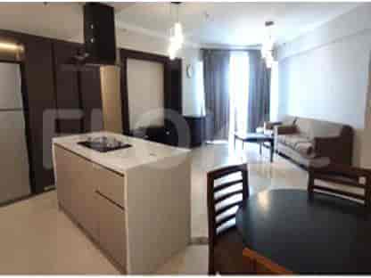 Area ruang tamu dan dapur terbuka dengan pulau modern, sofa, dan meja makan.