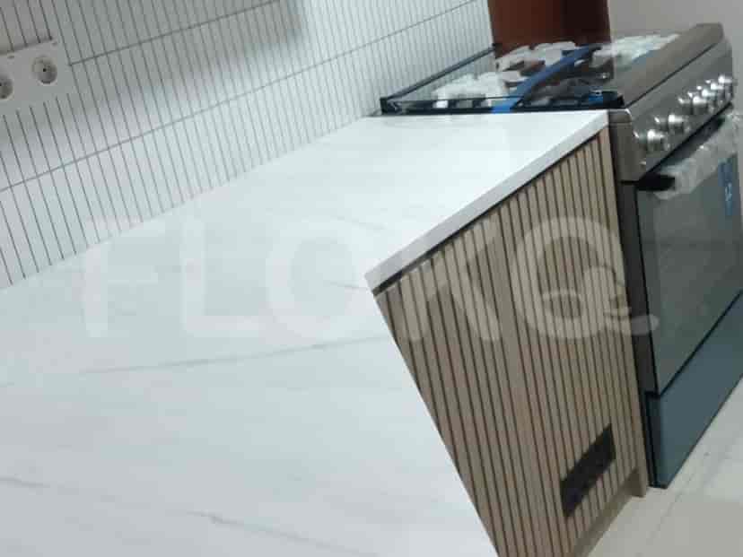 A kitchen counter with a marble countertop, a gas stove, and wooden cabinets.