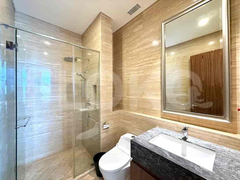 A modern bathroom with a walk-in shower, toilet, and a granite-top vanity.