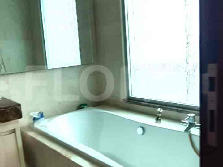 A bathroom featuring a bathtub, marble-like tiles, and a large mirror.