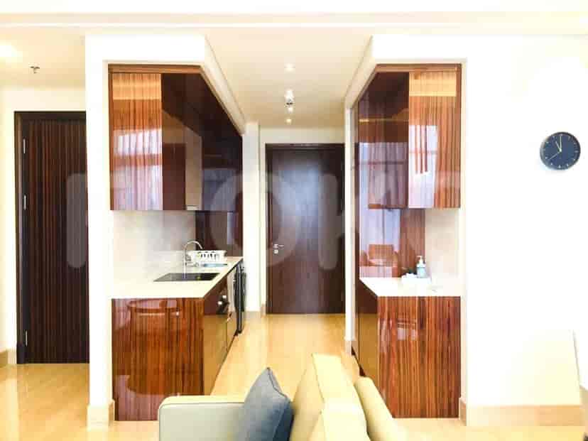 A modern kitchen with sleek wooden cabinets, white countertops, and built-in appliances.