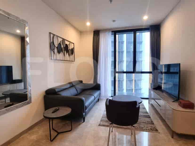 Ruang tamu modern dengan sofa kulit gelap, jendela besar dengan pemandangan kota, dan TV layar datar.