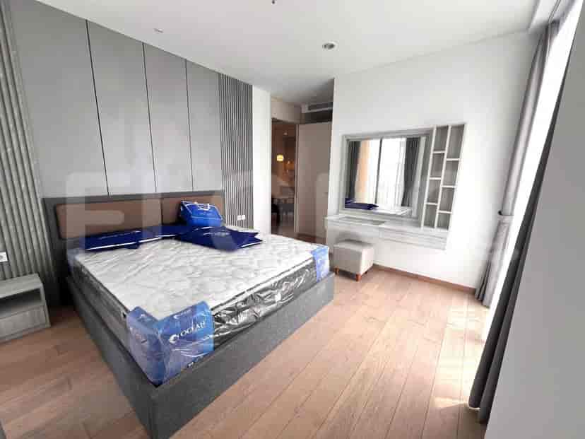 Sebuah kamar tidur dengan tempat tidur besar, meja rias, dan dinding aksen abu-abu.