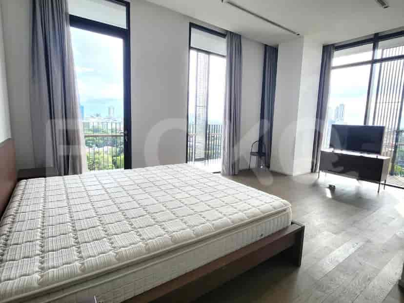 A bedroom with a large bed, floor-to-ceiling windows, and a city view.