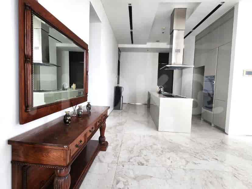 A modern kitchen with an island, integrated appliances, and marble flooring.