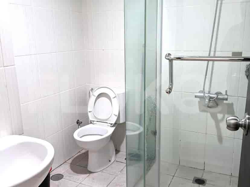 A clean and functional bathroom with a toilet, a sink, and a glass-enclosed shower stall.