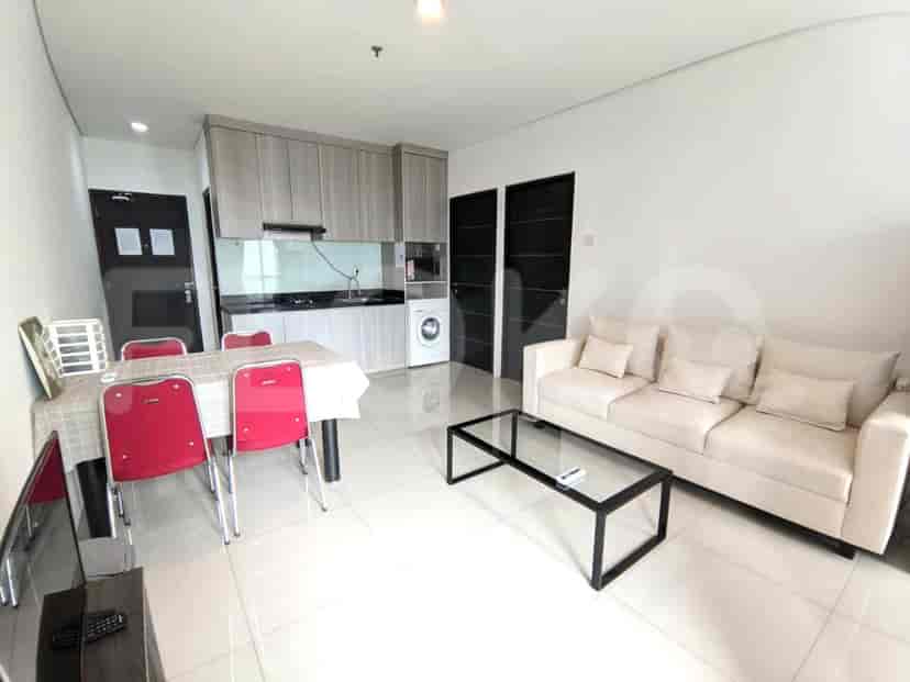 A combined kitchen and dining area featuring a dining set, a kitchenette with cabinets and appliances, and a washing machine.