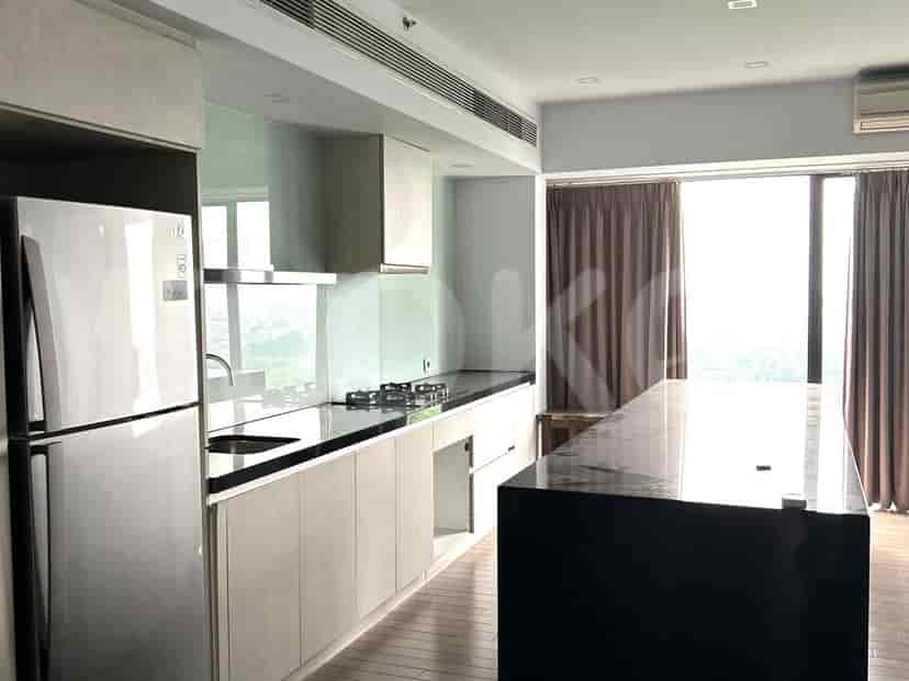 A modern kitchen with light wood cabinets, a dark island, and a stainless steel refrigerator.
