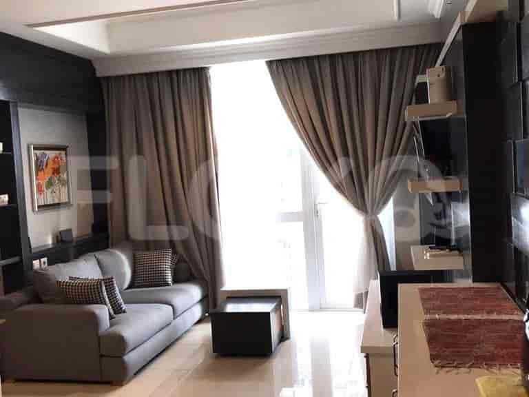 A modern living room with a grey sofa, coffee table, and large window.