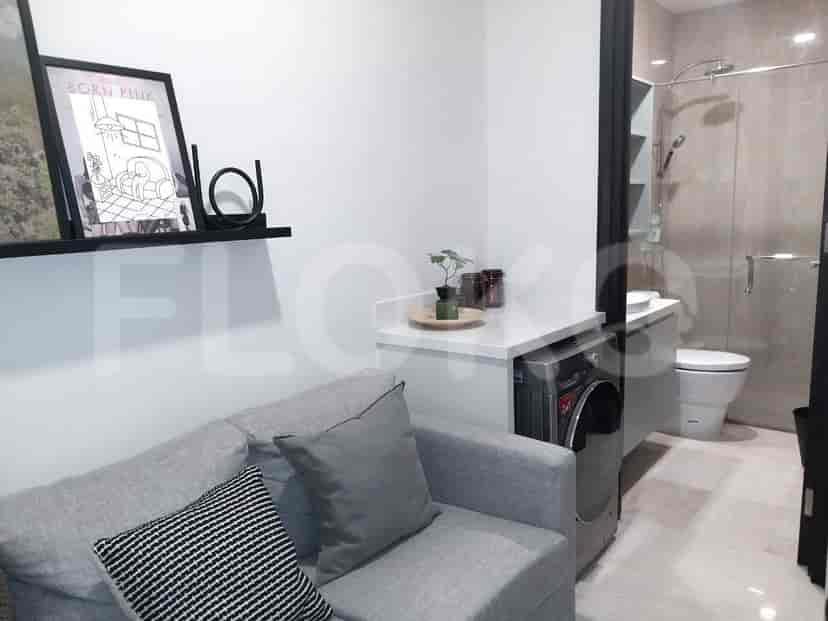 A seating area with a sofa and a glimpse of a bathroom with a washing machine.