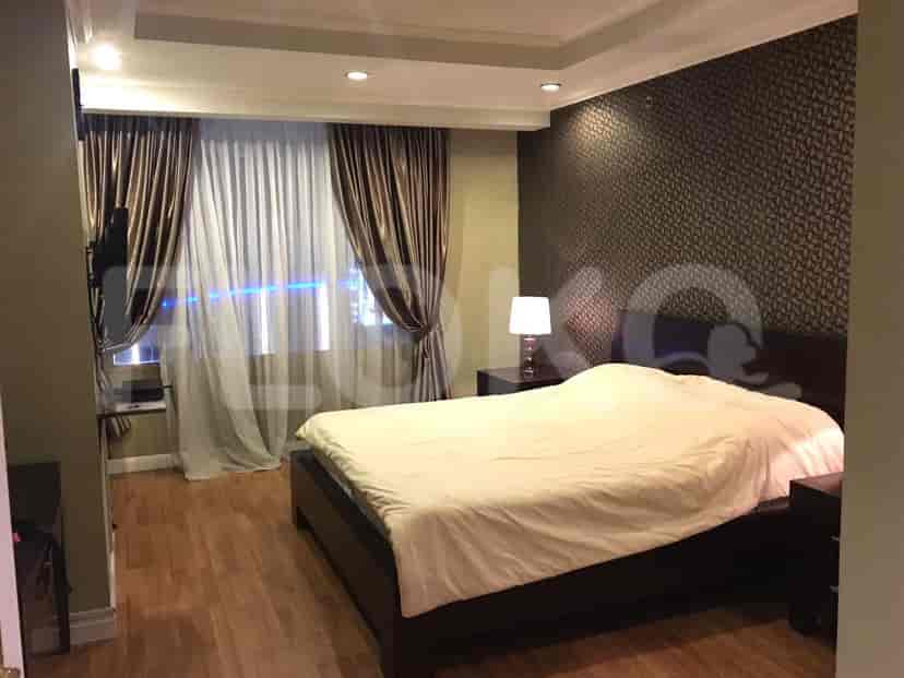 A bedroom with a queen-size bed, bedside tables, and curtains covering a large window.