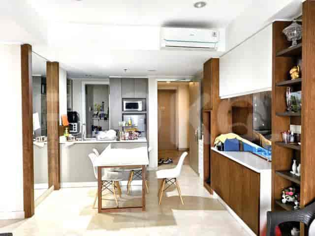 An open-plan kitchen and dining area with white cabinets, a dining table, and a breakfast bar.