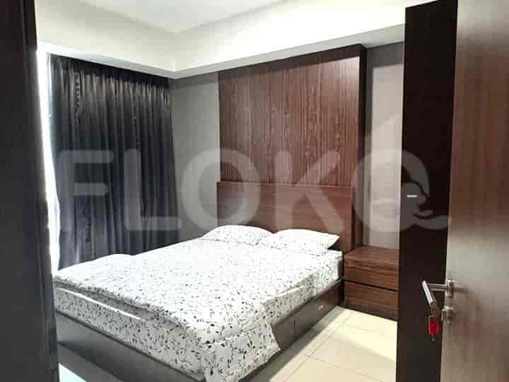 A cozy bedroom featuring a queen-sized bed with patterned bedding and a wooden headboard.