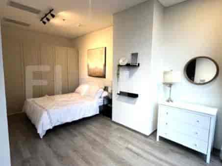 A bedroom with a queen-size bed, wardrobe, and a dresser.