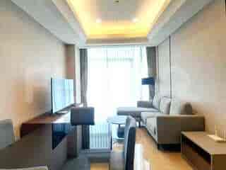 A modern living room with a large L-shaped sofa, a sleek media console with a TV, and a large window with curtains.