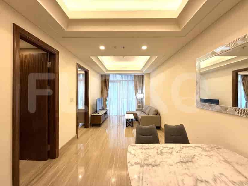 A modern living room with a sofa, TV, coffee table, and a dining table.