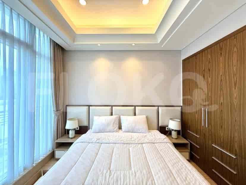 A bedroom with a king-sized bed, bedside tables with lamps, and a wooden wardrobe.