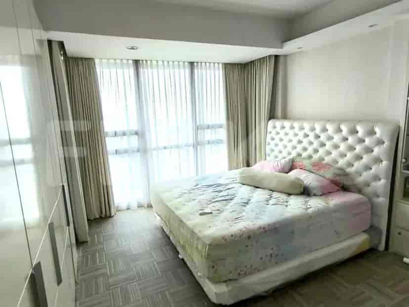 Kamar tidur utama dengan tempat tidur ukuran king dan jendela besar dengan tirai.