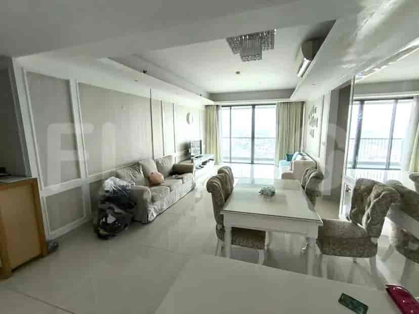 Area ruang tamu dan ruang makan yang luas dengan sofa besar, meja makan, dan akses balkon.