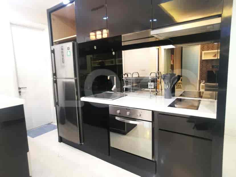 A modern black kitchen with stainless steel appliances, including a refrigerator and oven.