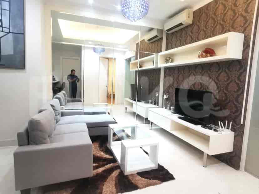 Modern living room with a large sectional sofa, mirrored walls, and a sleek entertainment center.