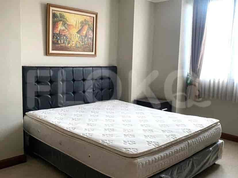 A bedroom with a queen-sized bed, a large headboard, and a nightstand.