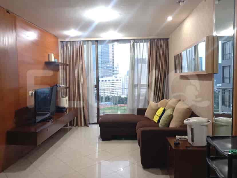 Ruang tamu modern dengan sofa sectional, unit hiburan, dan pintu kaca geser besar.