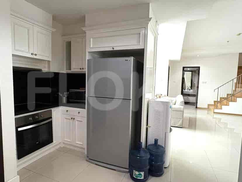 A modern kitchen with white cabinets, stainless steel appliances, and a water dispenser.