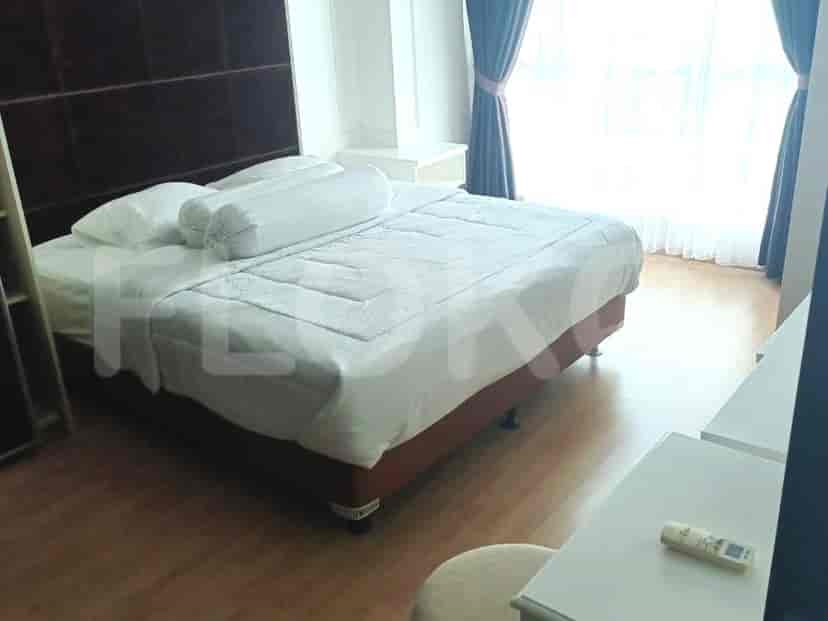 A bedroom with a large bed, pillows, and curtains.