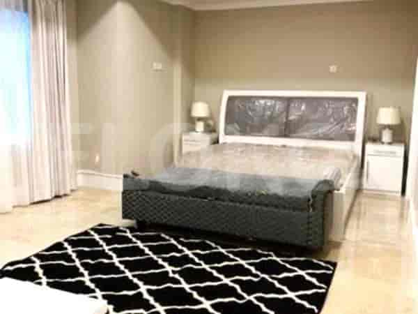 A bedroom with a large bed, nightstands, and a geometric rug.