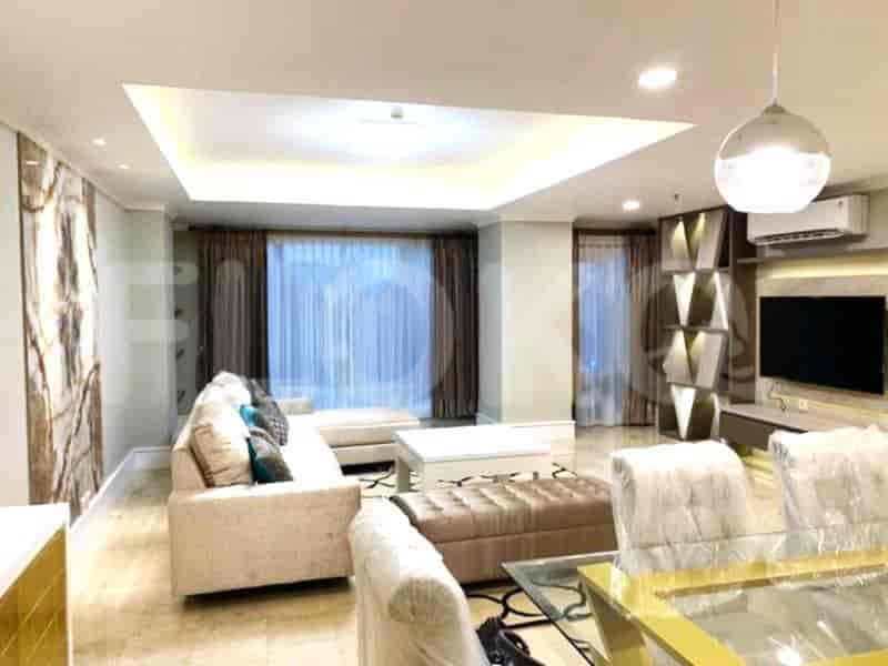 A luxurious living room with a large sectional sofa, coffee table, ottoman, and a decorative wall.