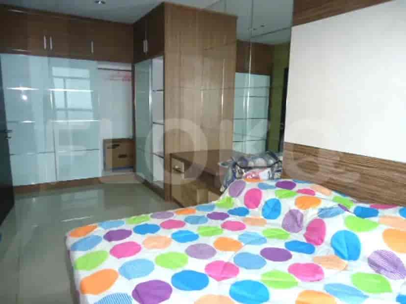 Kamar tidur dengan tempat tidur, lemari besar, dan panel dinding kayu.