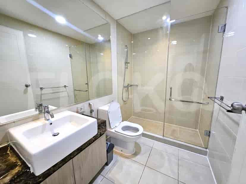 A contemporary bathroom with a white sink, toilet, and a glass-enclosed shower.