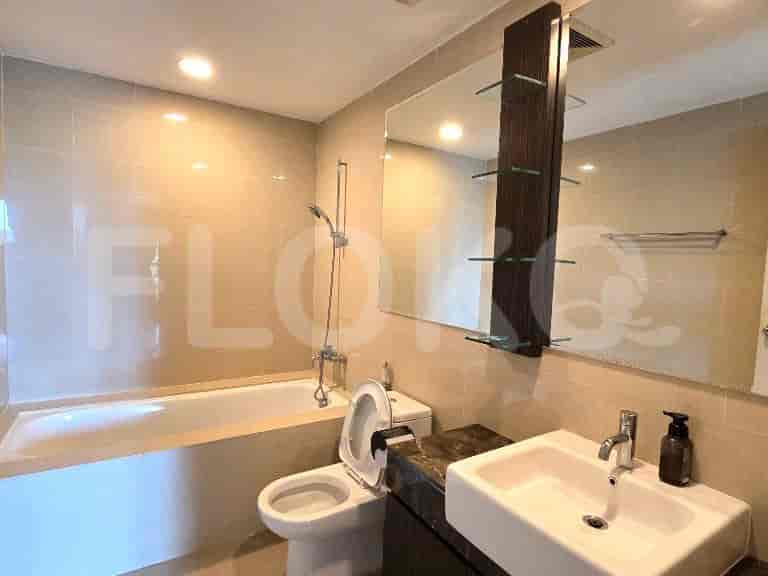 A clean bathroom with a bathtub, toilet, and vanity with a large mirror.