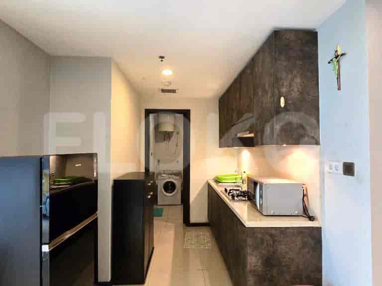 A compact kitchen with dark cabinets, a light countertop, and a small dining area.