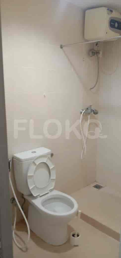 A compact bathroom with a toilet, shower, and water heater.