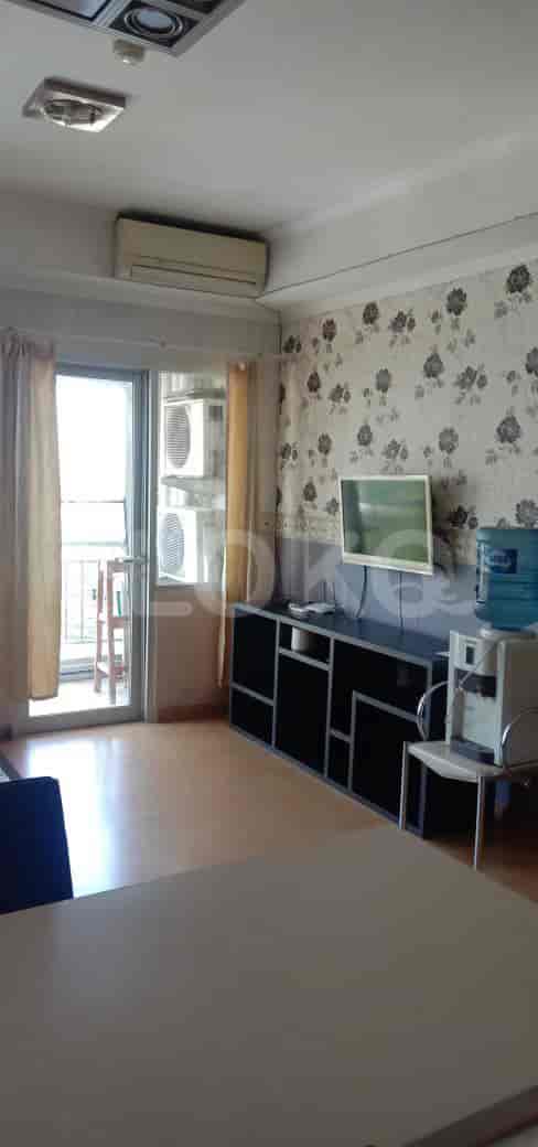 A living room with a TV, sofa, and air conditioning unit.